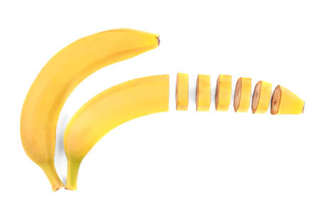 One whole banana and one-half of banana chopped into small pieces, isolated on a white background. Exotic bright yellow banana full of vitamins. Fresh tropical fruits.の写真素材