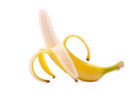 A whole banana, isolated on a white background. Ripe, fresh, organic, juicy and sweet peeled on a half banana. Bright yellow half-peeled banana. Tropical fruit concept.の写真素材