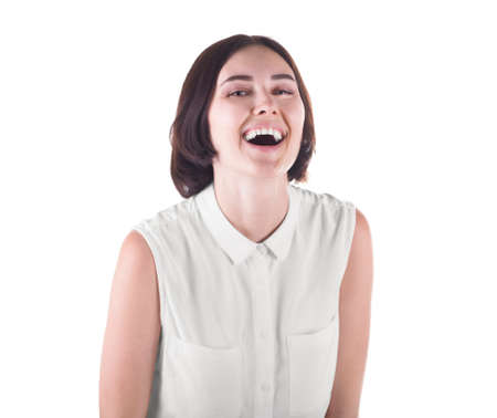 A joyful attractive young woman isolated over the white background. A confident and smiling female in a casual light blouse. A cute girl with a short black haircut.の写真素材