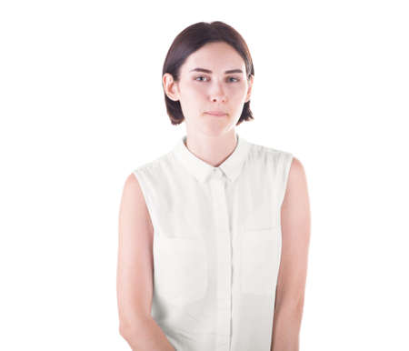 A curious young female isolated over the bright white background. A funny and adorable girl in casual clothing looking at the camera. A professional cute brunette woman.の写真素材