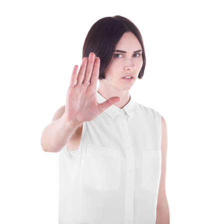 Beautiful brunette girl showing stop gesture with her right hand, isolated on a white background. Negative human emotions, facial expressions. Fashionable and elegant lady is showing stop.の写真素材