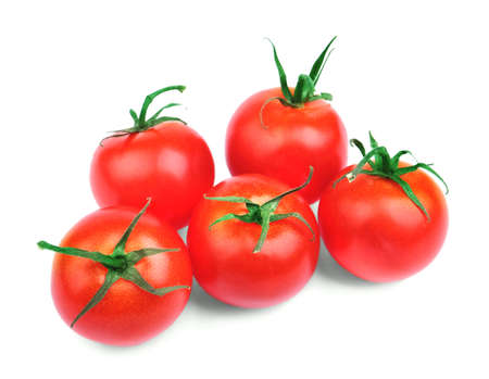 A few colorful fresh tomatoes isolated over the white background. Five perfect round red tomatoes with saturated green leaves. Nutritious vegetables for tasteful summer salads.の写真素材