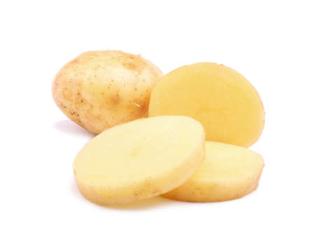 Fresh tasty potatoes cut into perfect round slices. Uncooked potato tubers isolated over the bright white background. A whole potato root and a half of a tuber. Nutritious vegetables.の写真素材