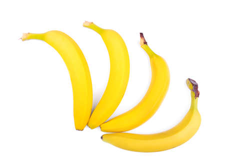 A group of four tasteful yellow bananas isolated over the white background. Healthful and organic exotic fruits. Ingredients for nutritious summer breakfast.の写真素材