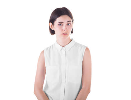Shocked and surprised young lady looking at the camera, isolated on a white background. An attractive girl is annoyed, shocked or bewildered. Sad woman.の写真素材