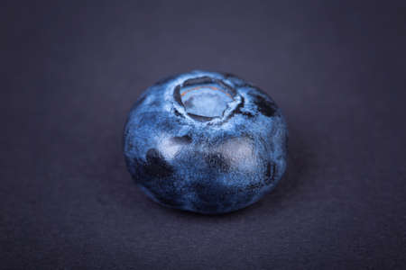 Close-up of a big, fresh and sweet blueberry. A single  blueberry on a dark background. Summer berry, top view. Fresh, healthful and tasty fruits. Ingredient for a healthy seasonal autumn breakfast.の写真素材