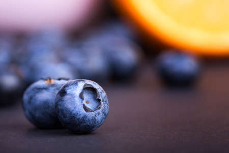 A close-up of two nutritious blueberries on a purple blurred background. Tasteful and ripe bilberries. Refreshing and healthful blueberries for sweet, summer smoothies and desserts. Copy space.の写真素材