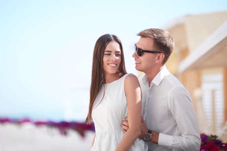 A couple on a vacation. Beautiful lovers on a sunny shore background. An adorable girlfriend and a smiling boyfriend. Copy space.の写真素材