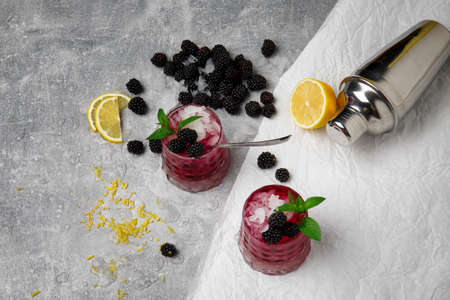 A view from above on composition of two glasses of fruit non-alcohol beverages with ice and...