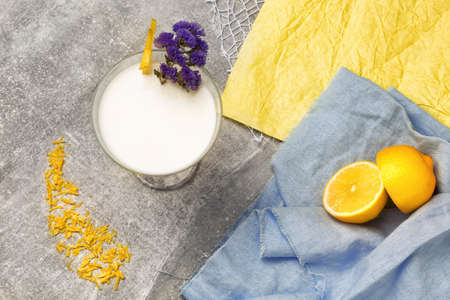 Top view of a shake on a table background. A glass of vanilla milkshake with carambola and flowers....