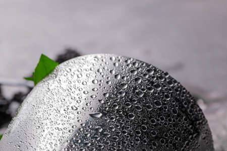 Closeup of a silver shaker with drops of water on a metallic surface, leaves of fresh mint on a gray blurred background.の写真素材