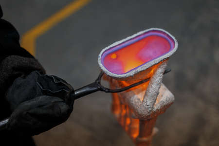 Hard work in the aluminum foundry. Steel factory. pink molten steel. Melting furnace on a black...