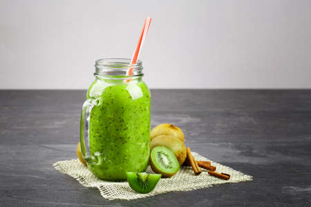 Smoothie for detoxification. Composition of healthy ingredients on a gray background. Glass of kiwi juice. Copy space.の写真素材