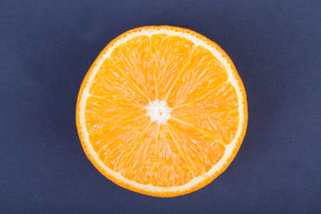 A top view of an organic half of orange on a dark purple background. Healthful and fresh citrus fruits.の写真素材