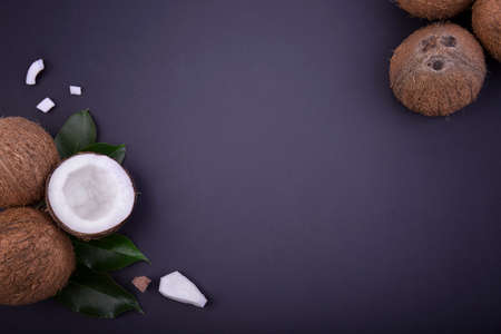 A top view of a composition of beautiful fresh coconuts. Four whole cocos and one half of a tropical fruit on a blue background.の写真素材