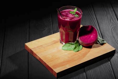 Beet products on a black background. Ripe beetroot and greens on a cutting desk. Vegetarian cafe concept. Copy space.の写真素材