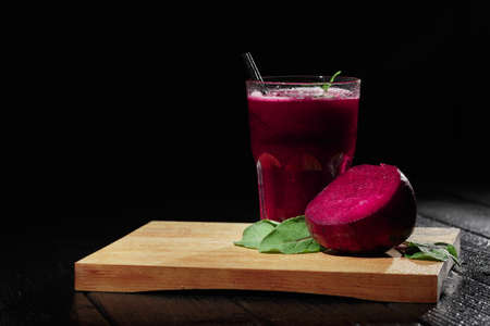 Beetroot on a cutting desk. Beet drink in a glass on a black background. Summer juices. Restaurant...