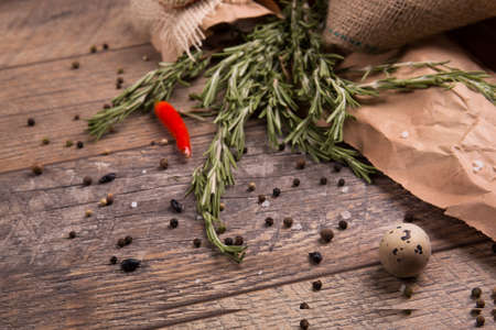 Fresh rosemary herbs. Red hot chili pepper. Egg with black pepper. Many spices on a rustic background. Mexican cuisine.の写真素材