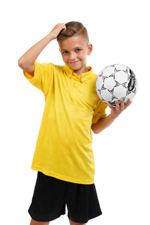 A happy boy with a ball. Active schoolboy. Young football player isolated on a white background. School soccer concept.の写真素材