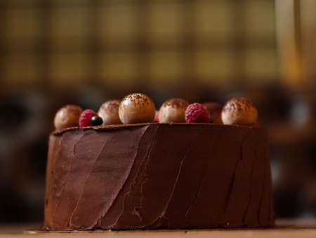 A close-up of a beautiful colorful chocolate cake. Creamy delicacy on a blurred background. Pastry...