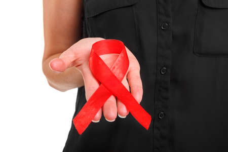 World AIDS Day concept. Red ribbon on a female hand isolated on a white background. Healthcare and...
