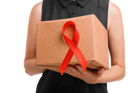 The red ribbon on a box. Woman holding AIDS awareness symbol isolated on a white background....