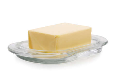 Close-up of a plate with organic butter, isolated on a white background. A nutritious block of butter. Natural food.の写真素材
