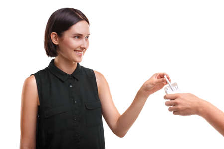 A carefree girl taking a cigarette. Young female trying to smoke isolated on a white background. Unaware youth concept.の写真素材
