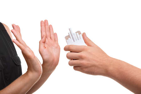 Close-up of a girl rejecting cigarette. Girl against smoking isolated on a white background. Addictive nicotine concept.の写真素材