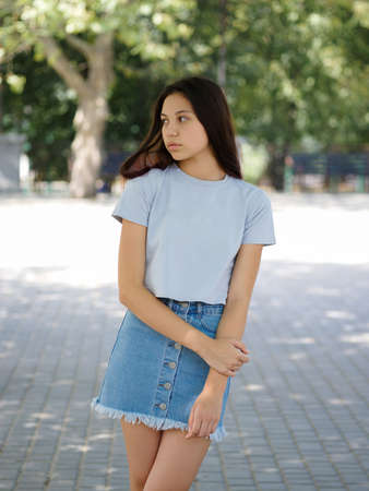 A cute young girl in casual clothes on a natural blurred background. Urban, fashion and youth concept. Copy space.の写真素材
