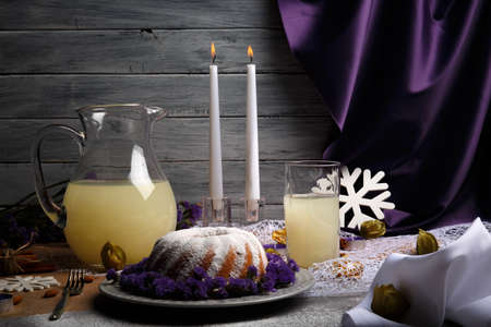 A healthy Christmas dessert with a lot of powder sugar and violet flowers on a plate and on a gray...