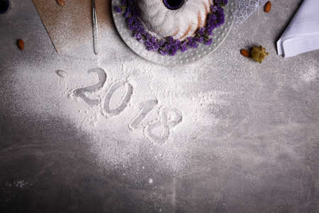 View from above of a 2018 sign next to a festive traditional Christmas cake on a frozen table background. A natural, pretty, homemade cake decorated with exotic spices and flowers. Copy space.の写真素材