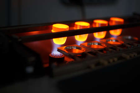 Close-up of four glowing bright forms for melting metal, steel or bronze on a dark industrial background. Professional manufacturing equipment for metallurgical business and roasting technologies.の写真素材