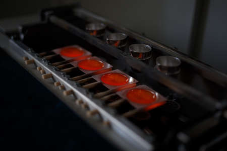 Close-up picture of a professional smelting gold machine in process. A bright red melting steel in...