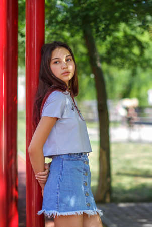 A trendy girl in fashionable hipster clothes on a blurred natural background. Fashion, outdoors, youth concept. Copy space.の写真素材