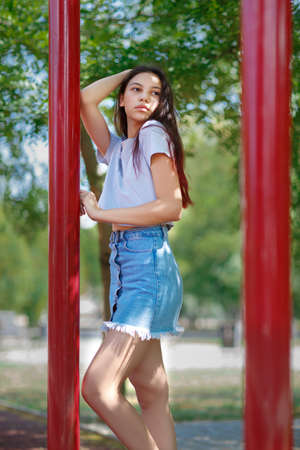 A trendy girl in fashionable hipster clothes on a blurred natural background. Fashion, outdoors, youth concept. Copy space.の写真素材