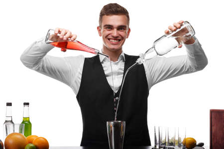 An attractive bartender at a bar counter doing a cocktail, a plate of lime isolated on a white background.の写真素材