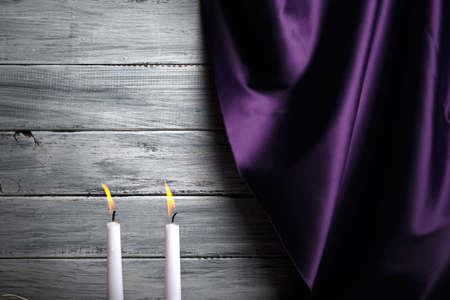 A silk purple curtain, two burning candles, romantic evening with beloved on a light gray background.の写真素材