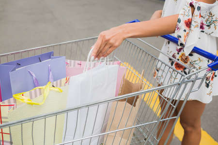 After day shopping in the mall. Close-up of young woman carrying shopping bags in a trolley,の写真素材