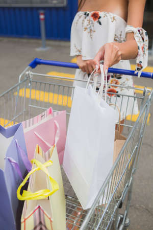 After day shopping in the mall. Close-up of young woman carrying shopping bags in a trolley,の写真素材