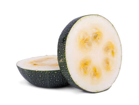 Close-up of two slices of natural and organic zucchini, isolated on a white background. Two pieces green zucchini with yellow seeds. Fresh summer vegetables for salads.の写真素材