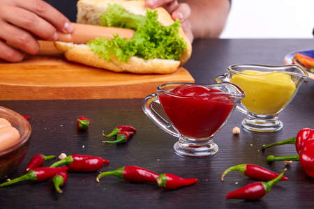 Hot dog with pickles, tomato and lettuce on wooden background. Top viewの写真素材