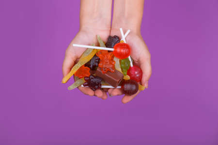 A lot of candies for babies holiday. Isolated on purple background.の写真素材