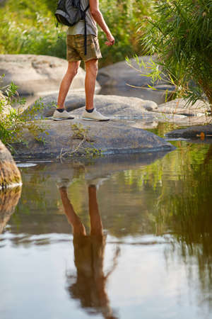 Man travel snikers on nature landscape. Strong legs hiking at mountain peak. Male travel snikers on nature landscape. Healthy hiker walking through the rocky land.の写真素材