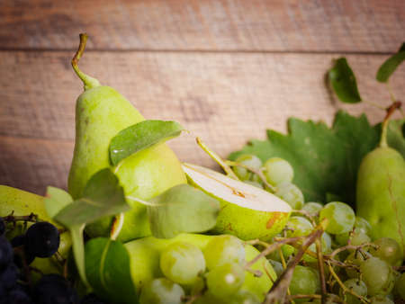 Green grapes and pears on a fabric background. Fresh, juicy grapes and pears. Fruit juice ingredients.の写真素材