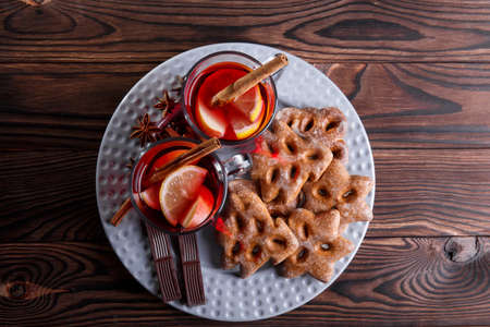 Cups of red tea and a plate of cookies with chocolate on a table background. Sweet tea and bakery. Christmas sweets.の写真素材