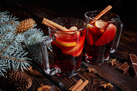Cups of lemon tea with cinnamon and chocolate on a pine branch and table background. Tea and chocolate.の写真素材