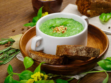 Green vegetable cream soup with celery and broccoli. Black bread with garlic and onions. Crackers of white bread. Many fresh and healthy vegetables. Close-up of cream soup. Copy space. Food concept.の写真素材