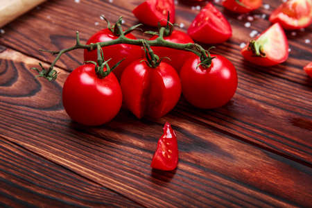 Close-up bright red small cherry tomatoes on a wooden table background. Nutritious tomato vegetables for vegetarians.の写真素材