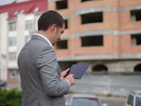 Mature man with a tablet on the office background. Businessman working on a tablet. Copy space.の写真素材